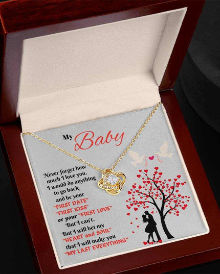 yellow gold love knot necklace in a luxury box tilted up to the left