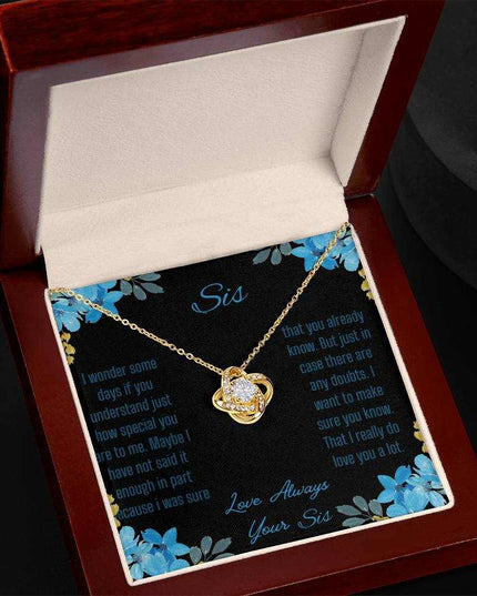 Love Knot Necklace with a yellow gold variant on a To Sis from Sis greeting card close up in a mahogany box angled to the left side