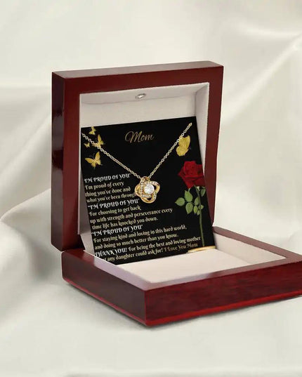 yellow gold love knot necklace in mahogany box angled left
