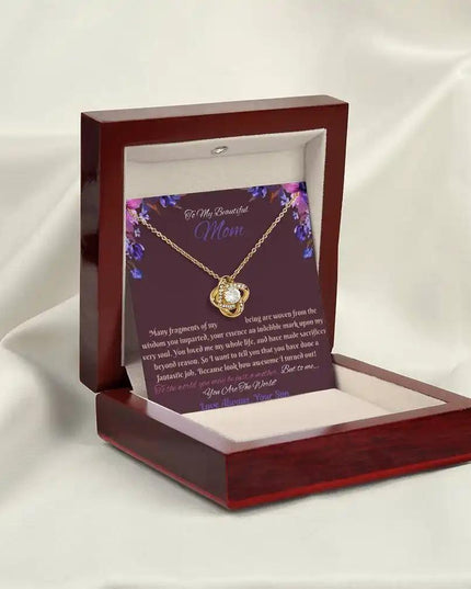 yellow gold love knot necklace in mahogany box angled left