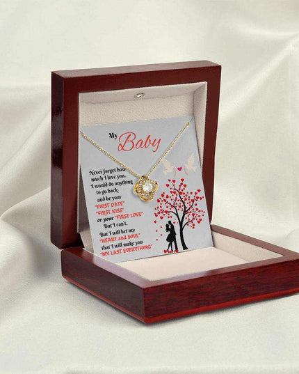 yellow gold love knot necklace in a luxury box angled left on fabric