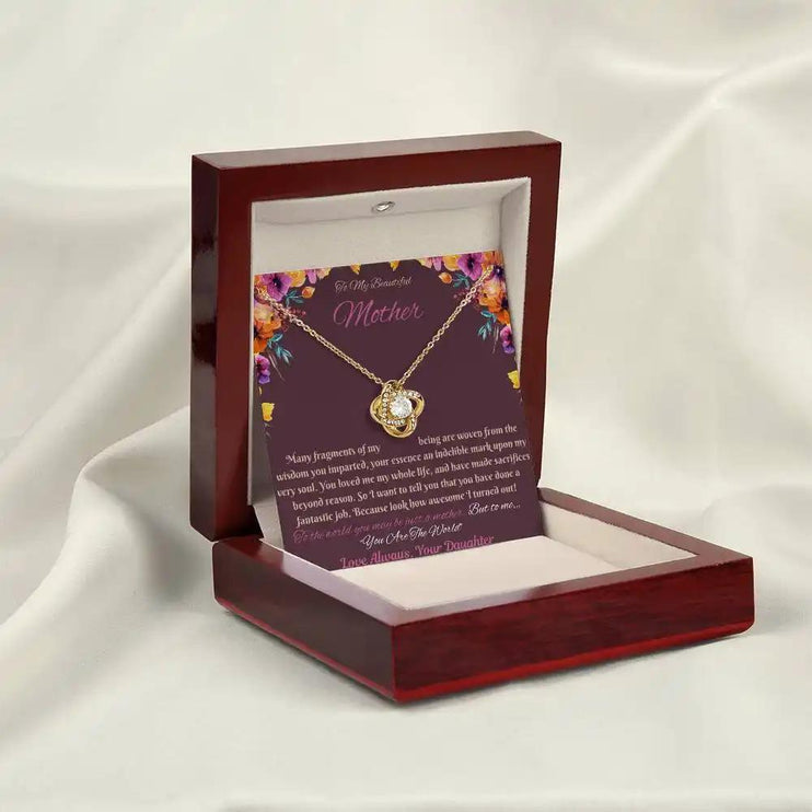 yellow gold love knot necklace in mahogany box angled left