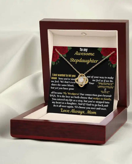 yellow gold love knot necklace in mahogany box on a white cloth