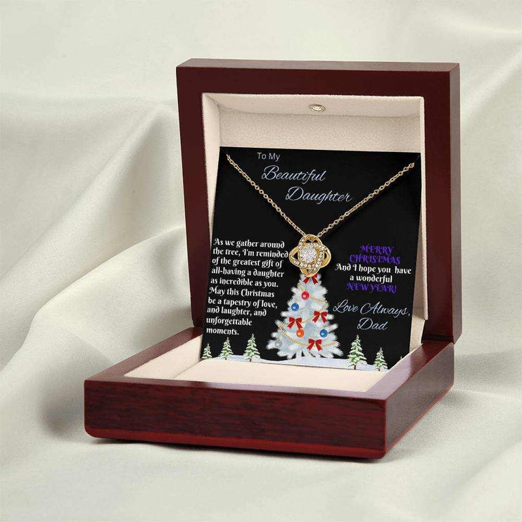 yellow gold love knot necklace in a luxury box on a white cloth backdrop