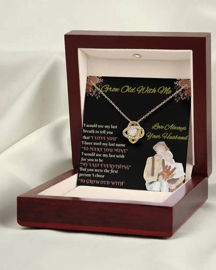 yellow gold love knot necklace in mahogany box on white cloth
