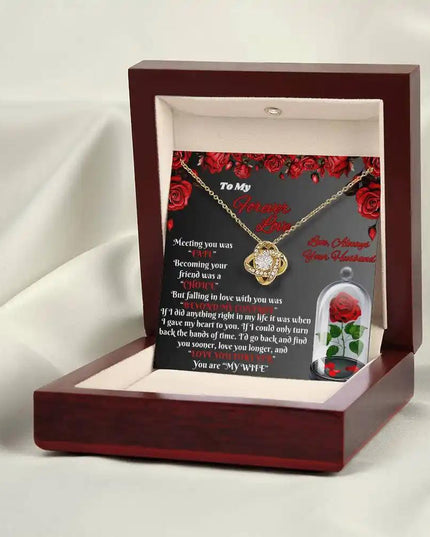yellow gold love knot necklace in mahogany box on white cloth