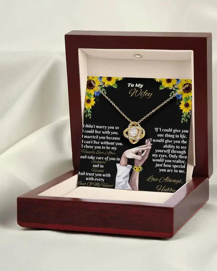 yellow gold love knot necklace in mahogany box angled right