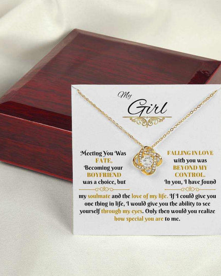 yellow gold love knot necklace outside of a closed luxury box