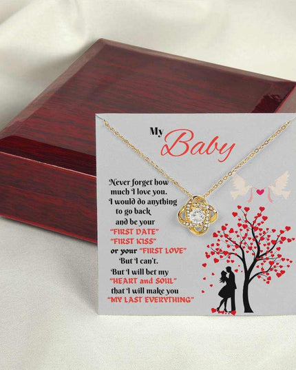 yellow gold love knot necklace outside of a closed luxury box