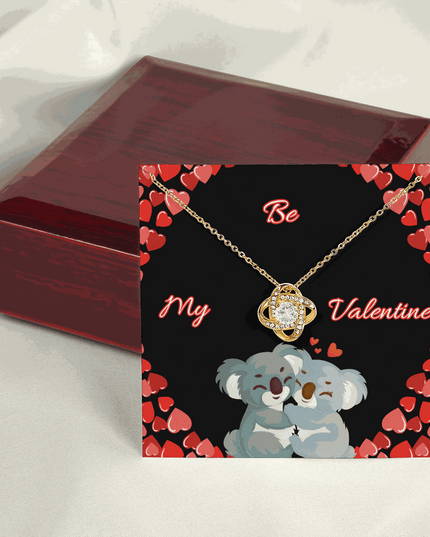 18k gold love knot necklace on top of a closed luxury box