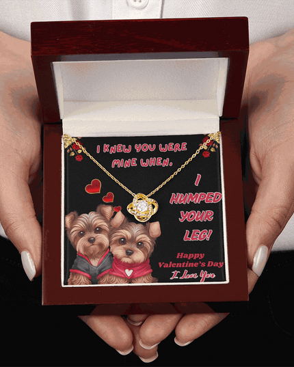 yellow gold love knot necklace in a luxury box in model's hands