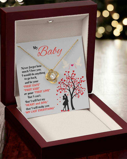 yellow gold love knot necklace in a luxury box angled left