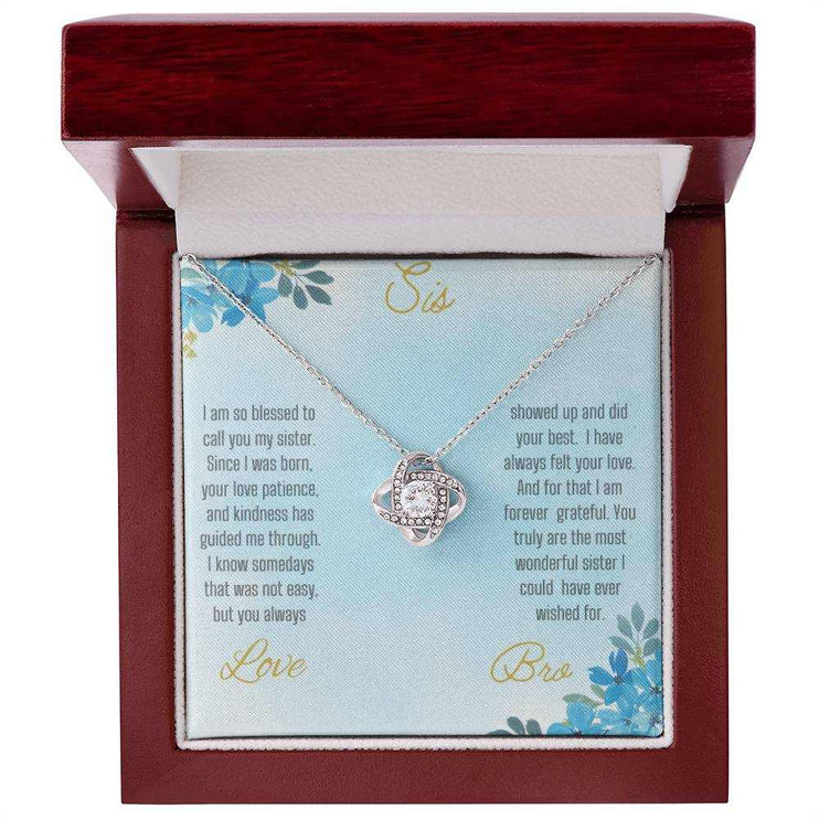 Love Knot Necklace with a white gold pendant on a To Sis from Bro greeting card inside of a mahogany box close view