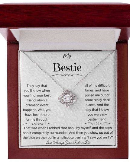 a white gold love knotnecklace up close in a mahogany box.