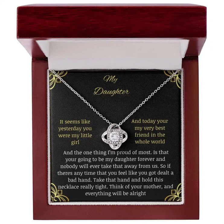 Love Knot Necklace with a white gold charm in a mahogany box with a to daughter from mom greeting card close up