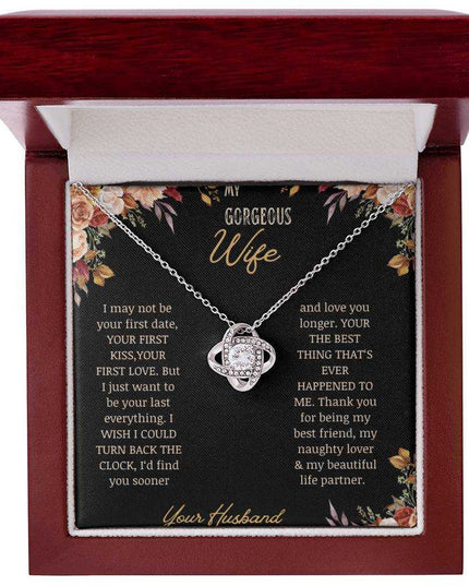 A white gold love knot necklace on a to wife greeting card in a mahogany box