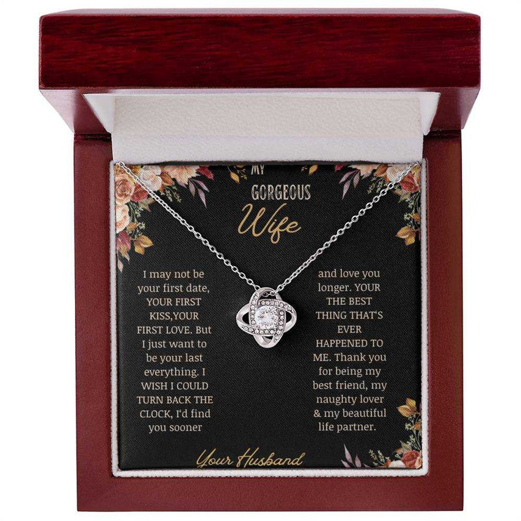 A white gold love knot necklace on a to wife greeting card in a mahogany box