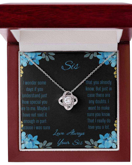 Love Knot Necklace with a white gold variant on a To Sis from Sis greeting card close up in a mahogany box