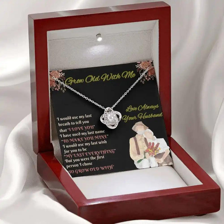 white gold love knot necklace in mahogany box on white cloth