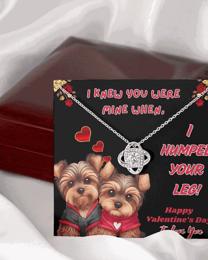 white gold love knot necklace on a message card outside of a closed luxury box