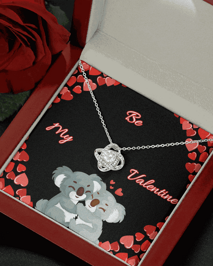 14k white gold love knot necklace in a mahogany box angled right