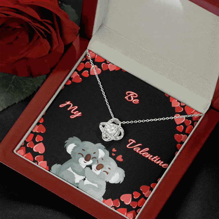 14k white gold love knot necklace in a mahogany box angled right