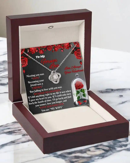 white gold love knot necklace in mahogany box angled left