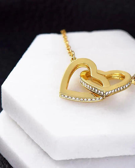 yellow gold interlocking hearts necklace on a display