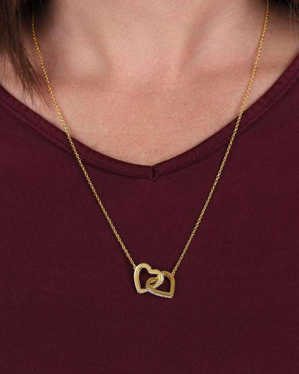 gold interlocking hearts necklace on a model's neck