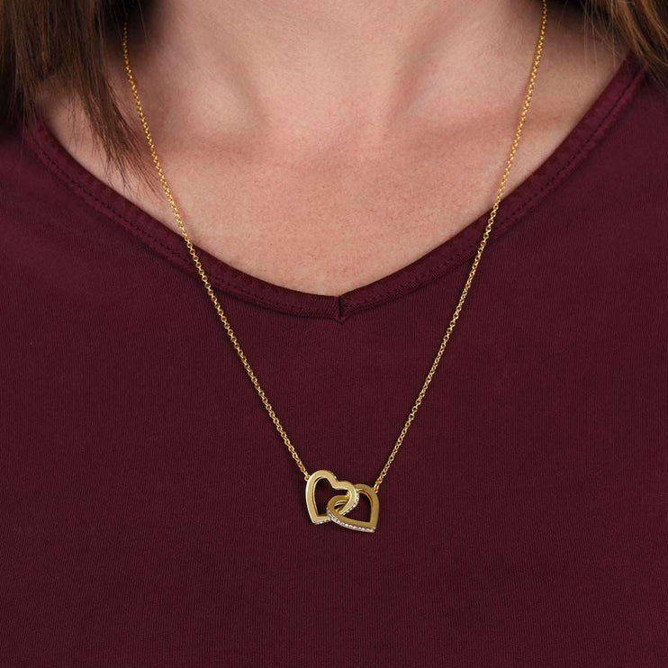 gold interlocking hearts necklace on a model's neck