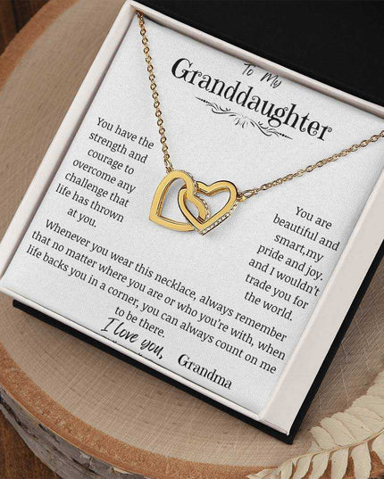 a yellow gold interlocking hearts necklace on a stump