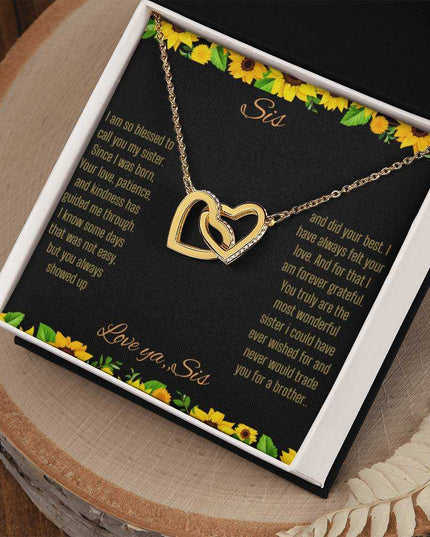 Interlocking Hearts Necklace with a gold on gold variant on a To Sis from Sis greeting card close up in a two-tone box angled to the right side