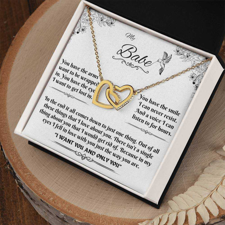 gold interlocking hearts necklace in a soft box angled to the right