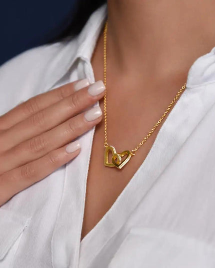 gold interlocking hearts necklace on model's neck