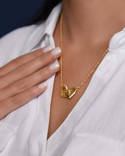 gold interlocking hearts necklace on a model's neck