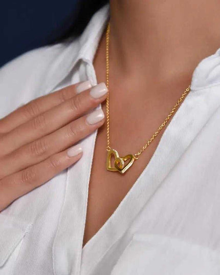yellow gold interlocking hearts necklace on a model's neck