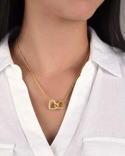 gold interlocking hearts necklace on a model's neck