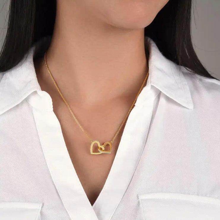 gold interlocking hearts necklace on a model's neck