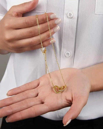 yellow gold interlocking hearts necklace in model's hand