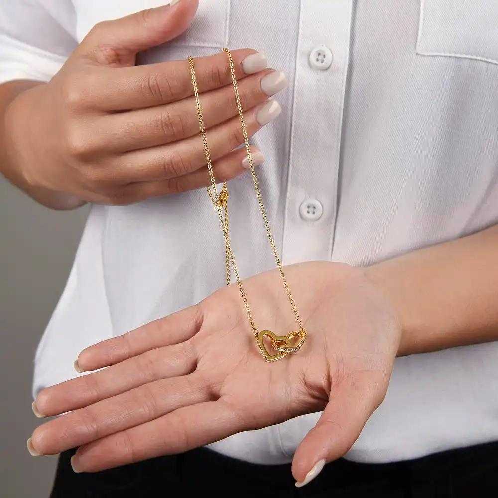 yellow gold interlocking hearts necklace in model's hand