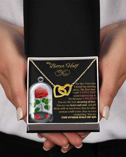 18k interlocking hearts necklace in a soft box in model's hands