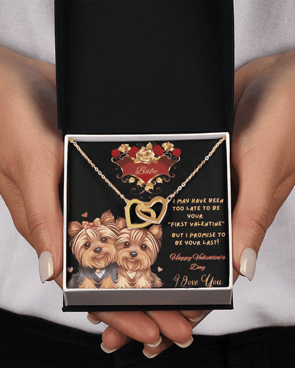 yellow gold interlocking hearts necklace in a soft box in model's hand