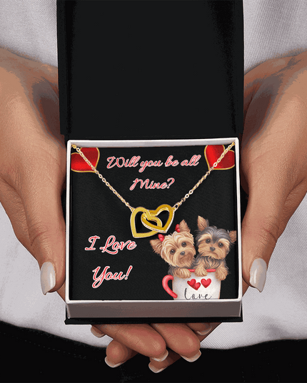 gold interlocking hearts necklace in a soft box in a model's hands