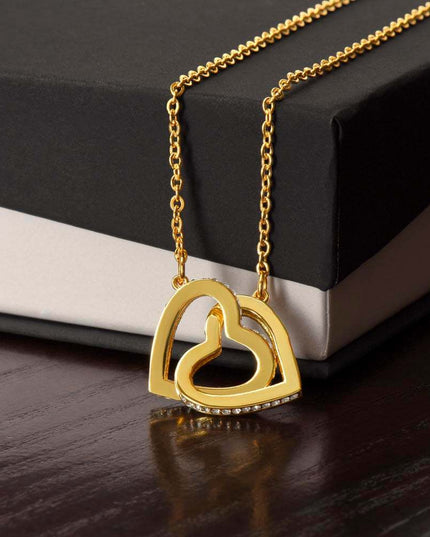 18k interlocking hearts necklace on top of closed soft box