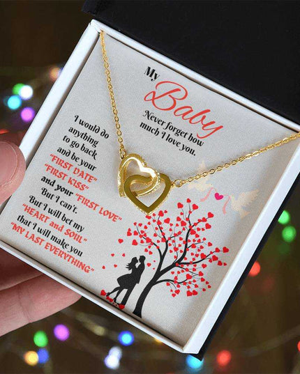 gold interlocking hearts necklace in soft box in model's hand