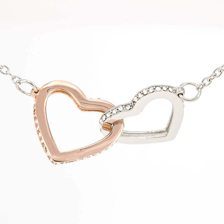 rose gold interlocking hearts necklace on white back drop