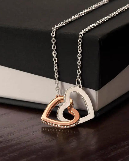 rose gold interlocking hearts necklace on top of a two-tone box