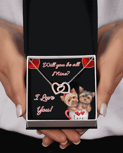 rose gold interlocking hearts necklace in a soft box in a model's hands