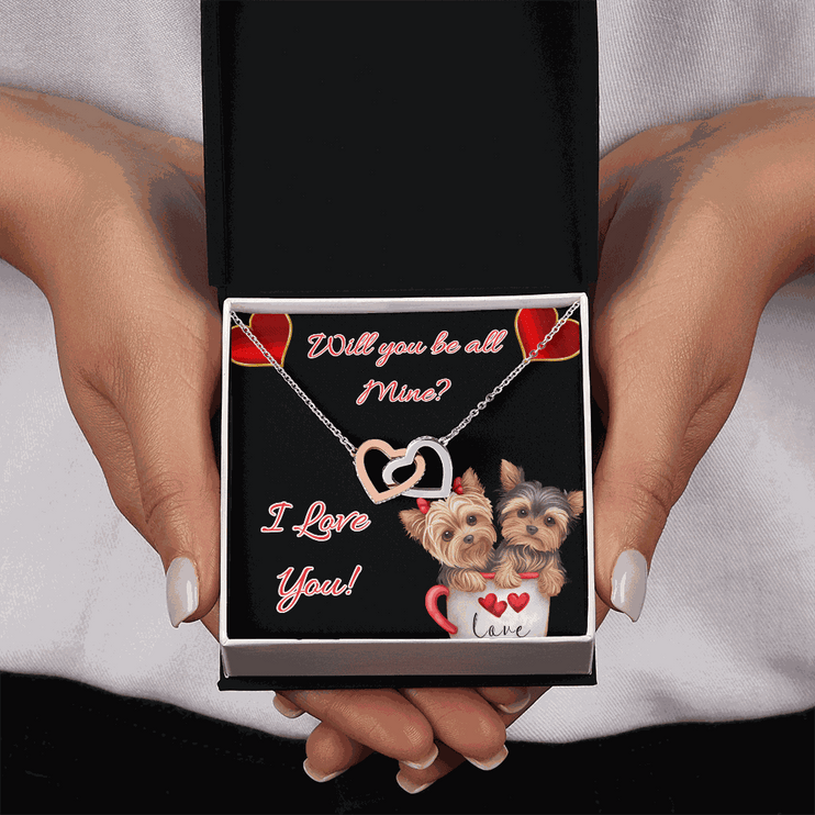 rose gold interlocking hearts necklace in a soft box in a model's hands