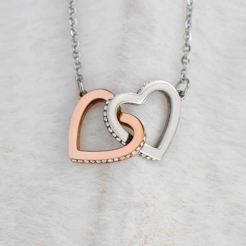 rose gold interlocking hearts necklace on a white felt background